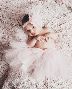 High angle view of baby girl lying on bed