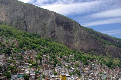 Houses by mountain against sky