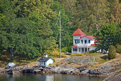 Building by river against trees