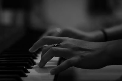 Cropped hands of woman playing piano