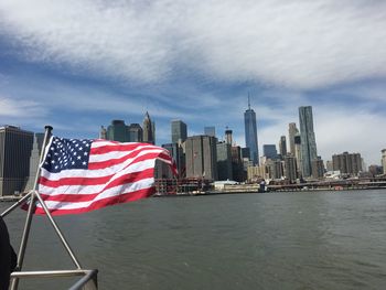 Flag by sea against sky in city