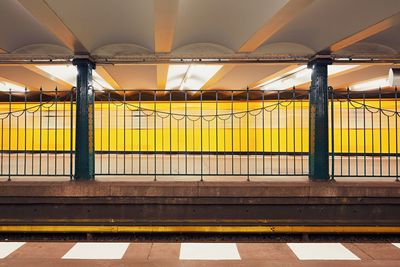 Blurred motion of train at subway station seen through fence