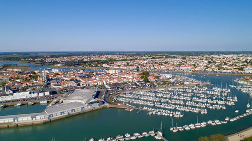 High angle view of sea by buildings against clear sky