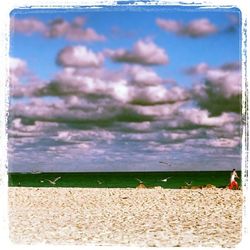 Scenic view of beach against cloudy sky