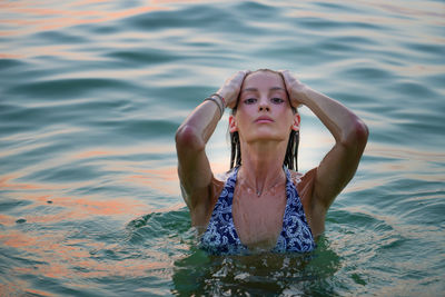 Woman swimming in the sea at sunset