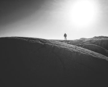 Silhouette man standing on desert against clear sky