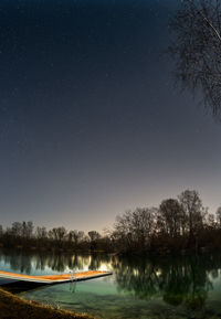 Scenic view of lake against sky at night