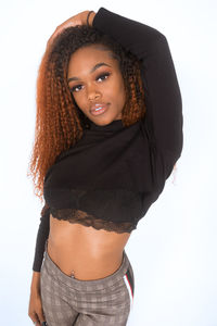 Portrait of young woman standing against white background