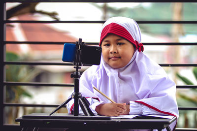 Portrait of girl sitting on table