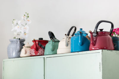 Close-up of multi colored kettles on shelf