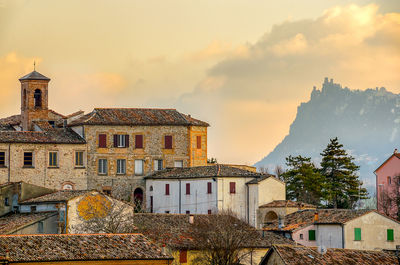 Buildings in town against cloudy sky