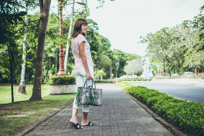Full length of woman on footpath amidst trees