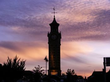 Low angle view of clock tower against cloudy sky