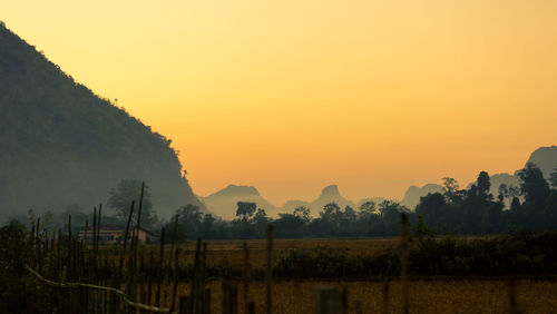 Scenic view of mountains against orange sky