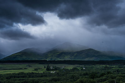 Scenic view of mountains against cloudy sky