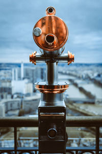 Coin-operated binoculars against cityscape