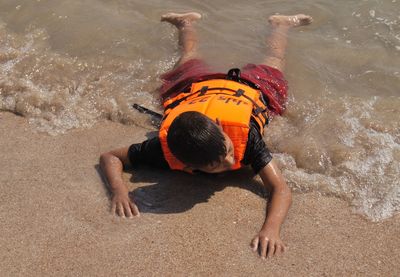 The boy swiming on sand