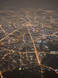 High angle view of illuminated cityscape against sky at night