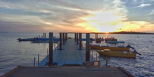 Pier on sea against sky during sunset