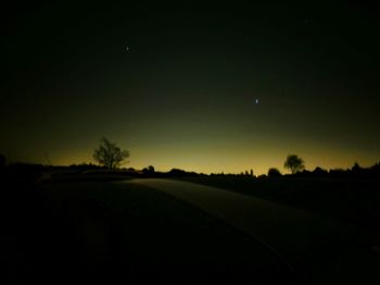 Scenic view of field against clear sky at night