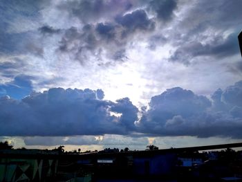 Silhouette houses against cloudy sky