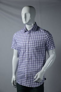 Button down shirt displayed on mannequin against backdrop 