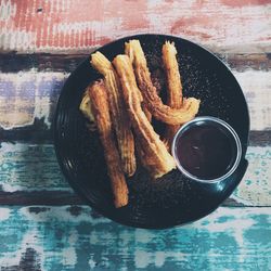 High angle view of churros and hot chocolate in plate on table