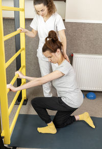 Rear view of woman sitting on floor