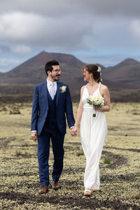 Portrait of couple standing against sky