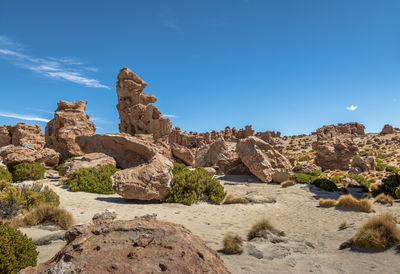 Low angle view of rock formations against clear blue sky