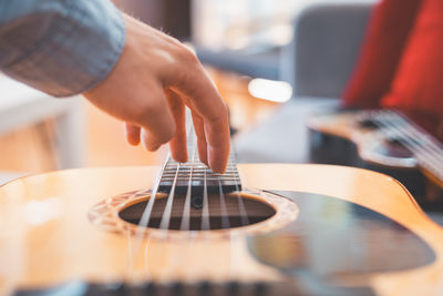 Midsection of man playing guitar