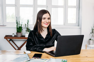 Portrait of smiling woman sitting at table