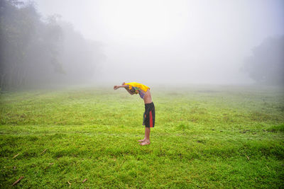 Full length of man standing on field during foggy weather