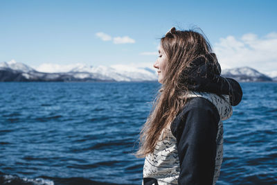 Rear view of woman looking at sea against sky