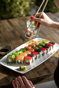 Cropped hands of woman having sushi at desk