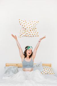 Young woman sitting on bed at home