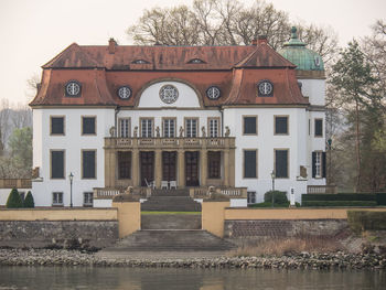 Building by lake against sky