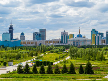 View of buildings in city against cloudy sky