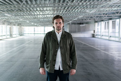 Portrait of young man standing in corridor