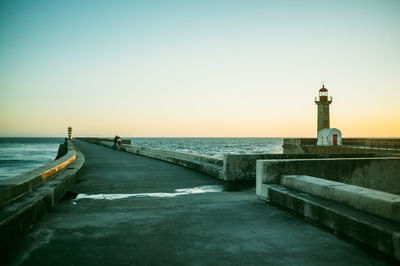 Pier on sea at sunset