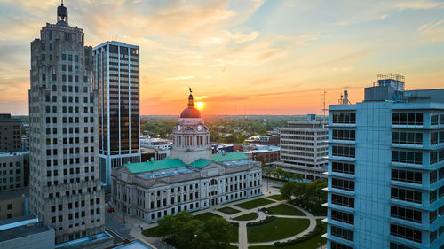 Buildings in city against sky during sunset