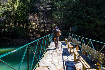 Rear view of man walking on footbridge