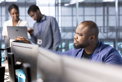 Side view of businessman using laptop at office