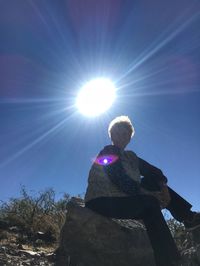 Low angle view of man standing against sun