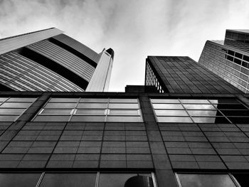 Low angle view of modern building against cloudy sky