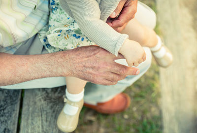 Low section of man with girl on lap siting outdoors