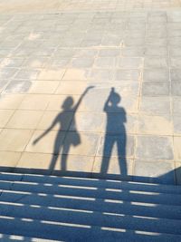 Shadow of people on cobblestone