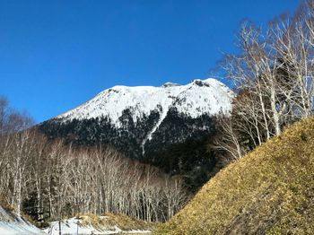 Scenic view of snowcapped mountains against clear blue sky