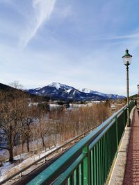 Street by snowcapped mountains against sky