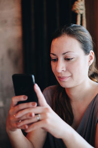 Woman using mobile phone in home